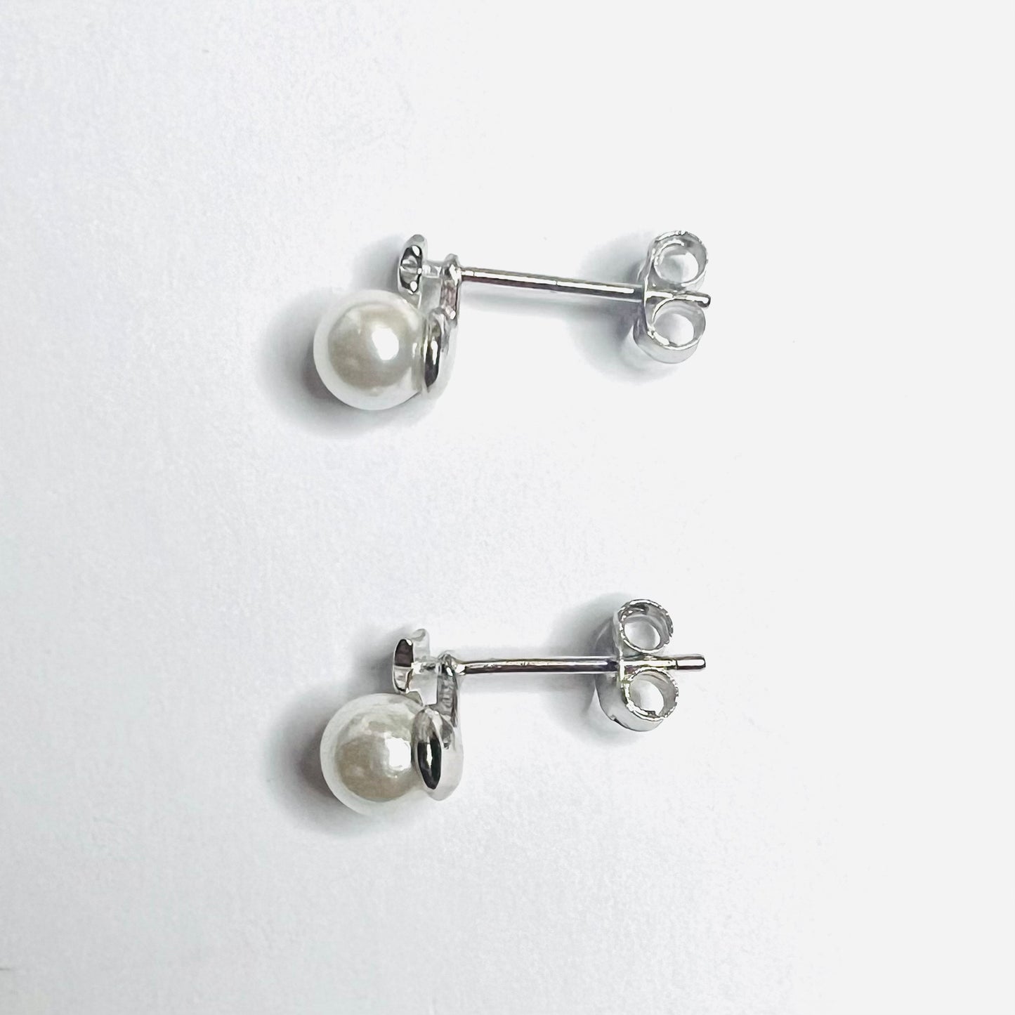 Aros en plata perla con pequeña estrella en parte superior